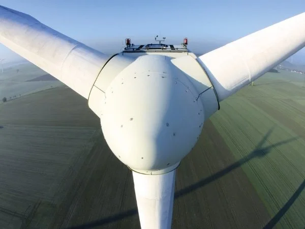 close-up on a wind turbine in a green landscape background